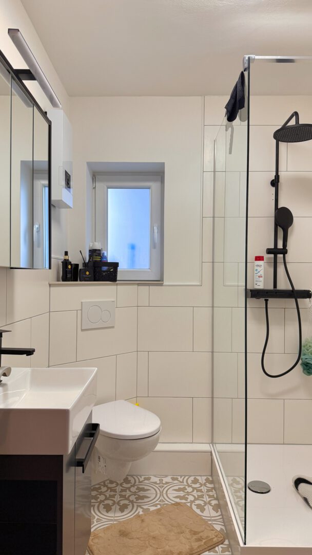 Modernes Gäste-WC mit ebenerdiger Dusche und stilvollen Fliesenakzenten (2)