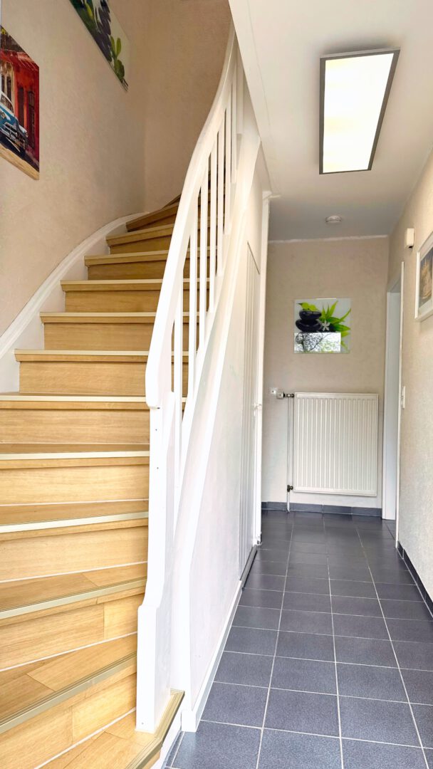 Heller Eingangsbereich mit Holztreppe ins Obergeschoss