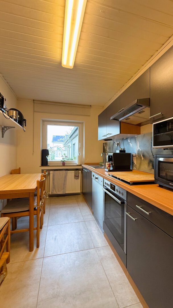 Küche mit Essbereich – funktional eingerichtet und mit Blick in den Innenhof